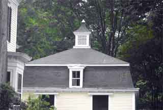 The mansard roof of this carriage house is topped by a cupola